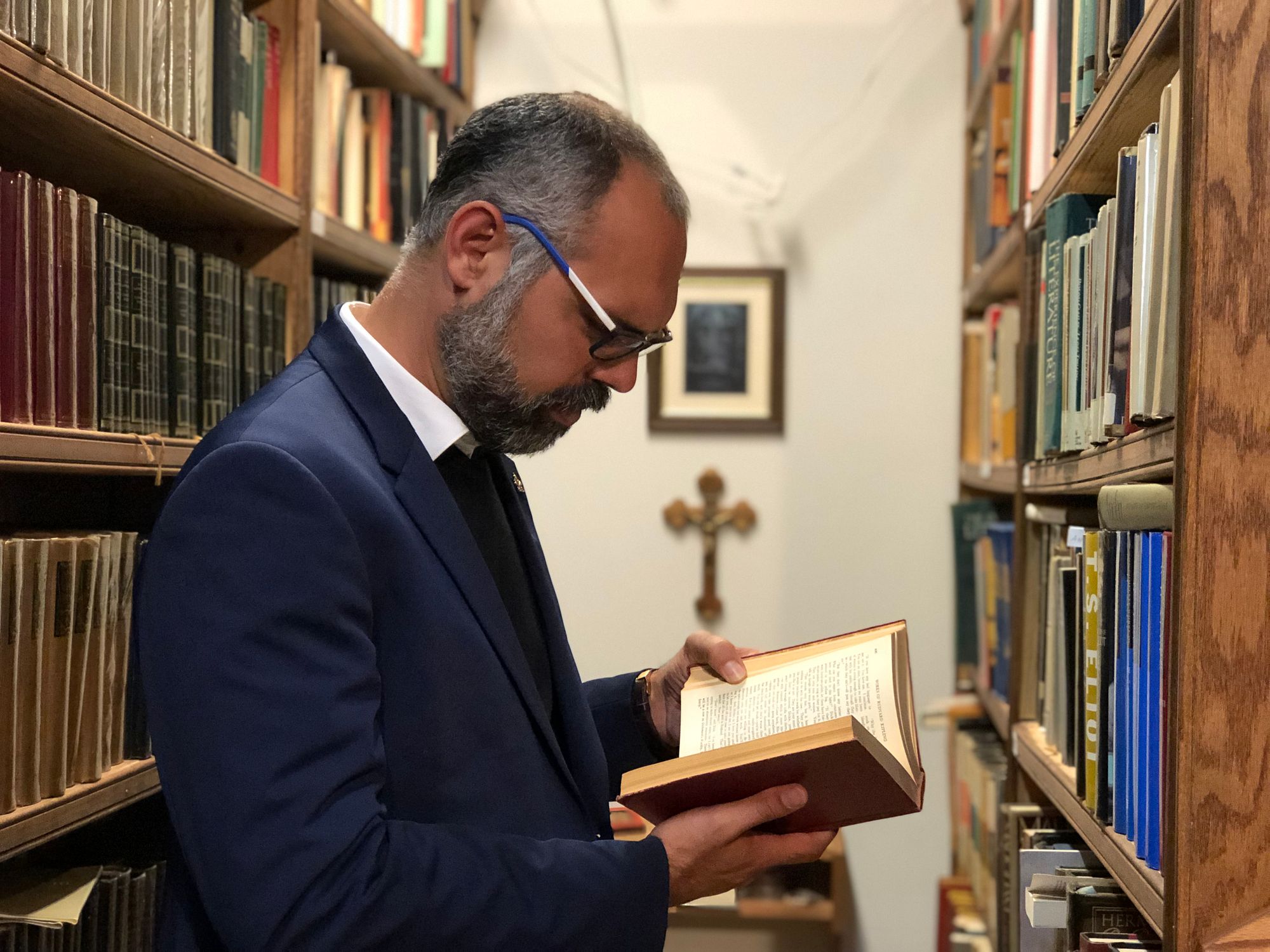 Allan Dos Santos reading a book in a library